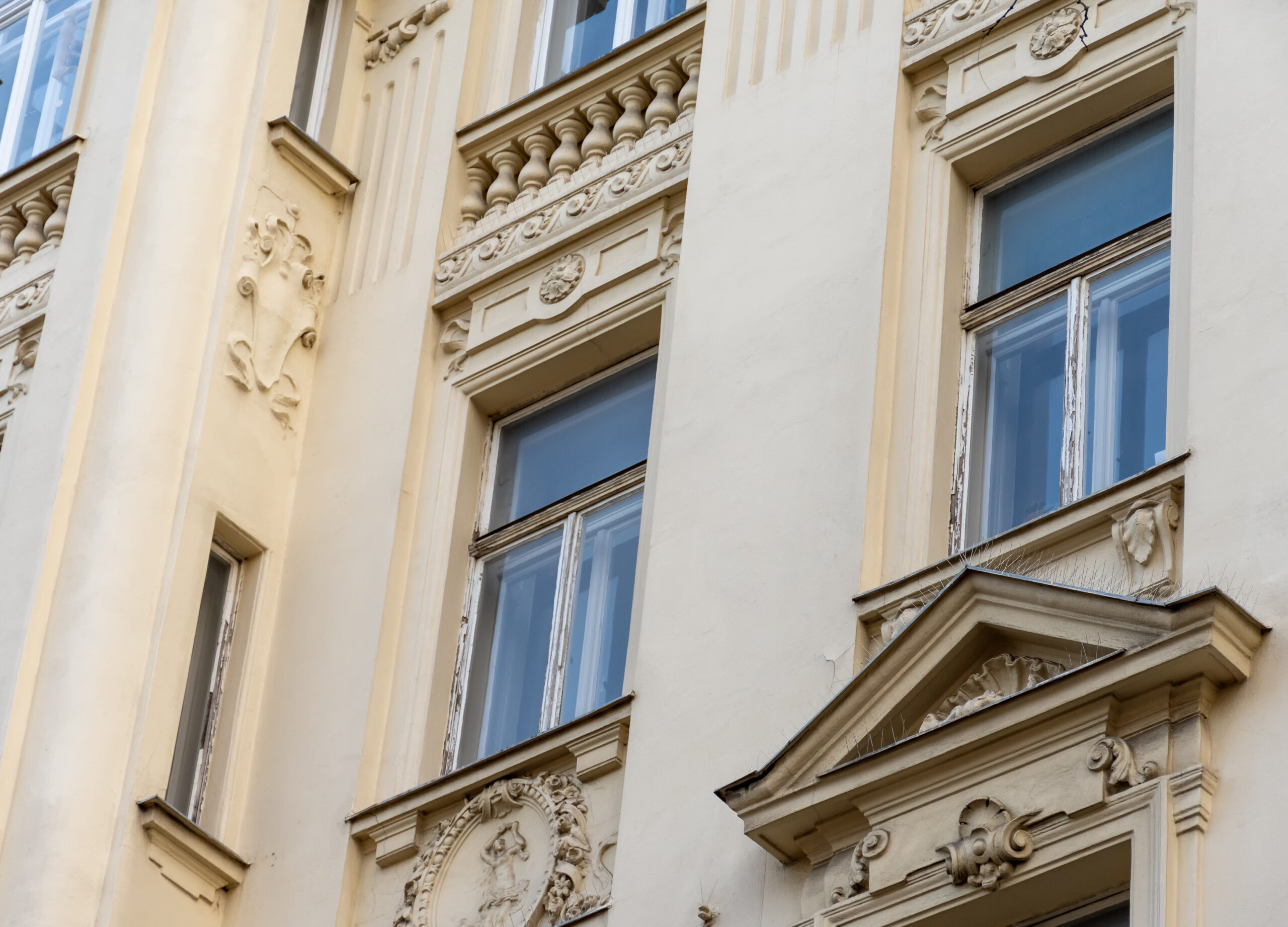 The facade of an old townhouse with decorative balconies and classic European architecture. The facade of an old townhouse with decorative balconies and classic European architecture.